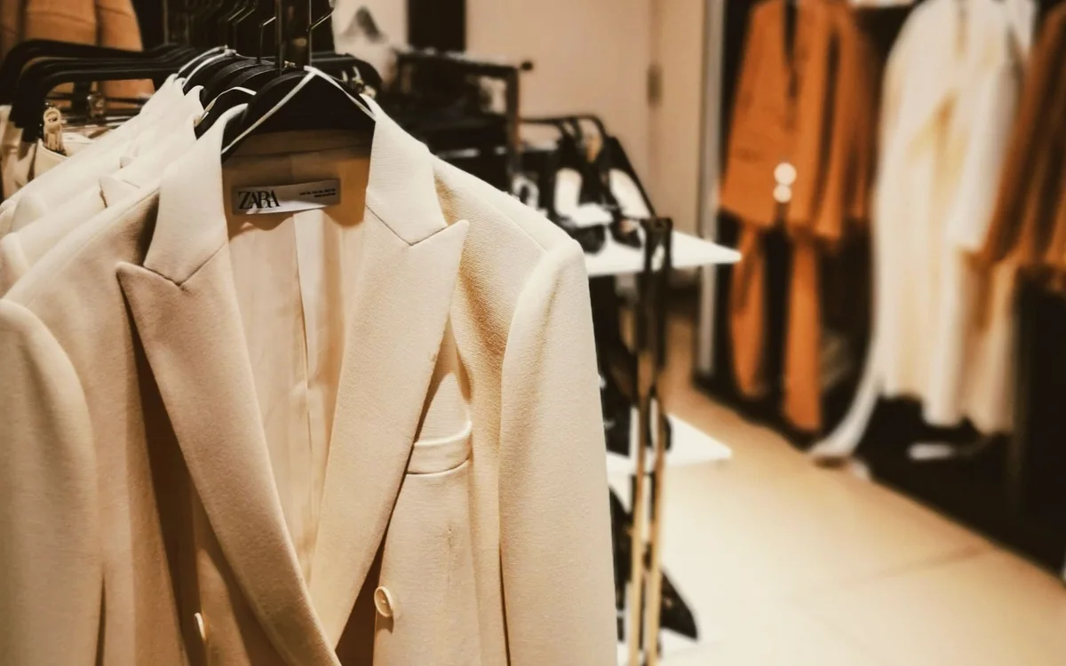 A person arranging folded clothes and shoes in a reach-in closet