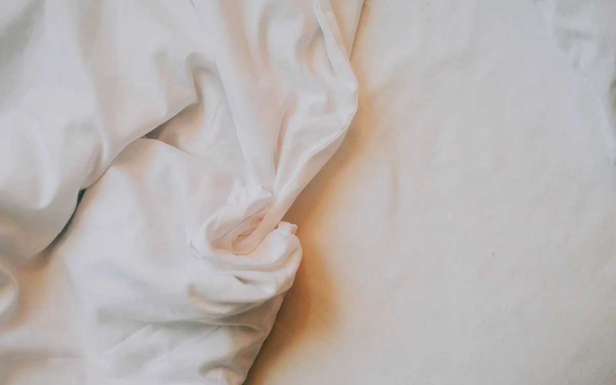 A guest bed with folded linens stored in drawers beneath the frame