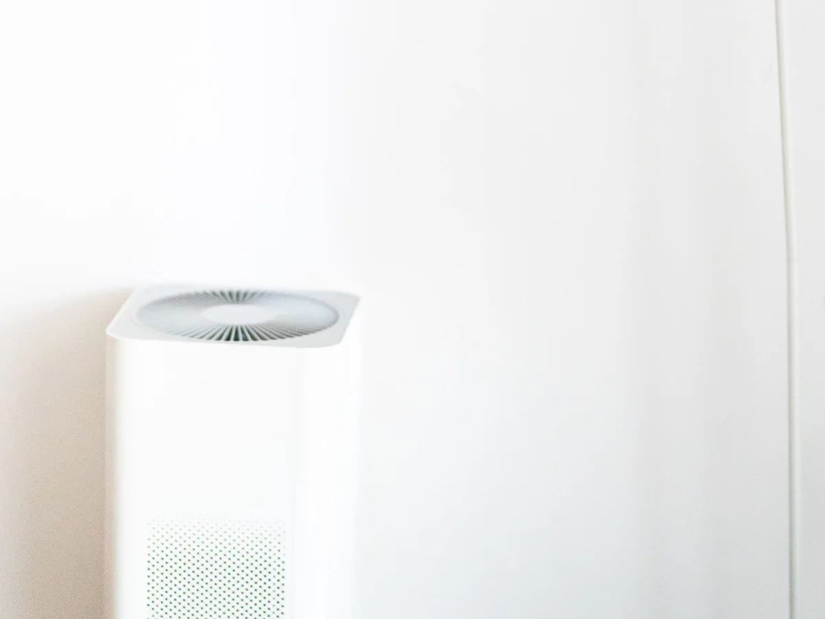 A bedroom humidifier on a nightstand with a hygrometer nearby