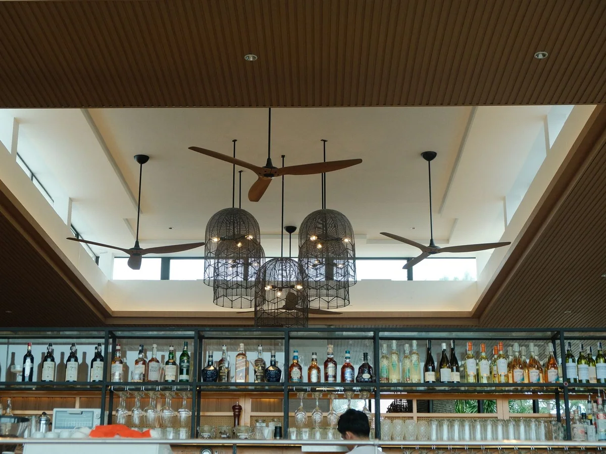 A quiet three-blade ceiling fan in a calm bedroom with a made bed