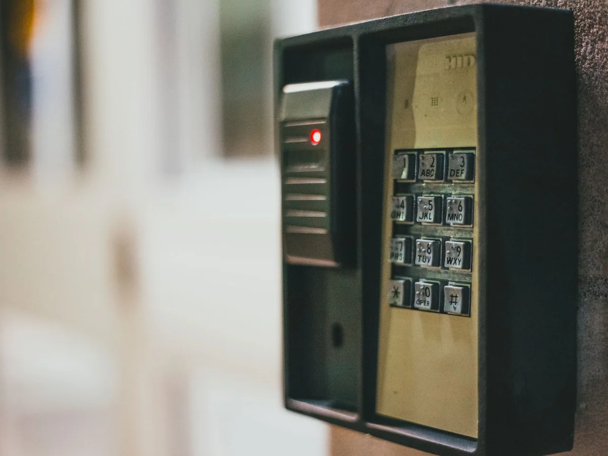 A keypad smart deadbolt on a home entry door with a family bag nearby