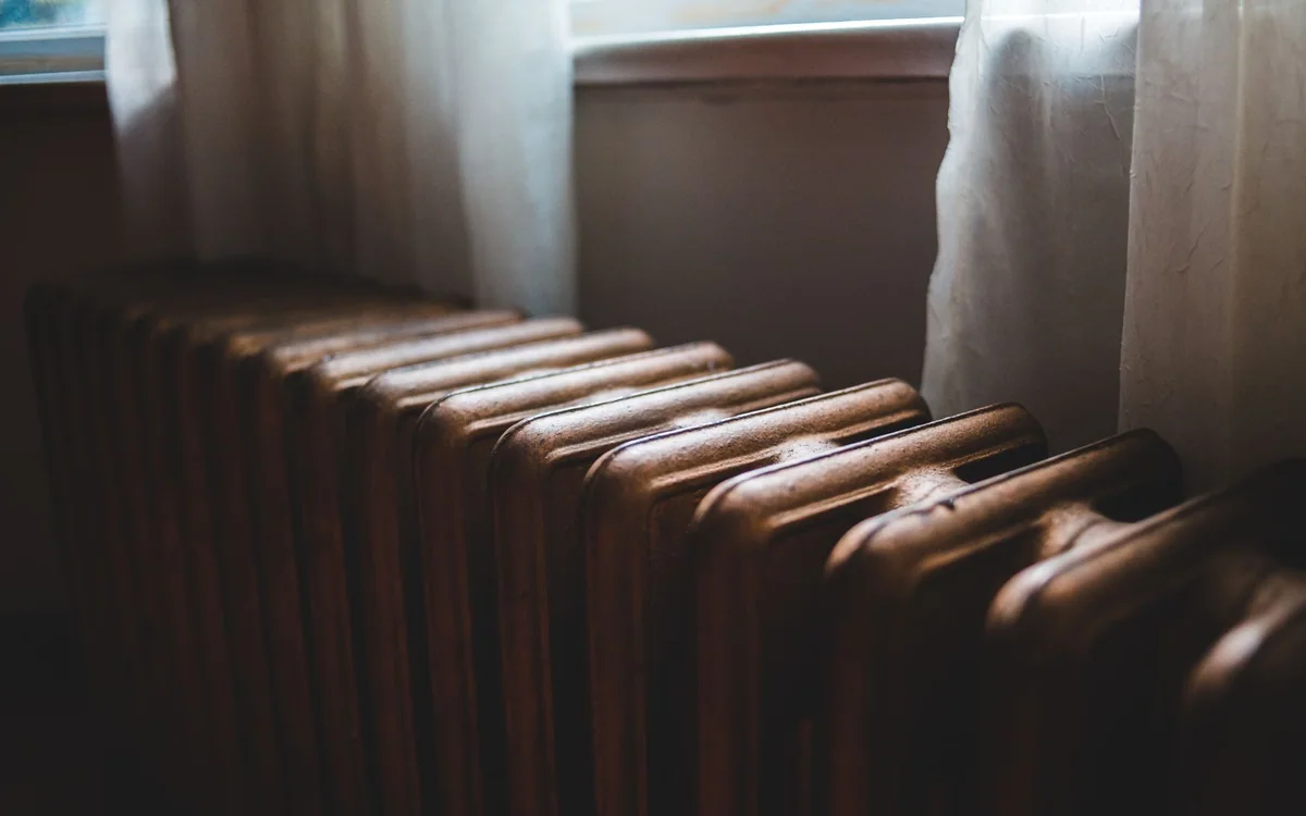 A renter checking a space heater's placement and safety clearance