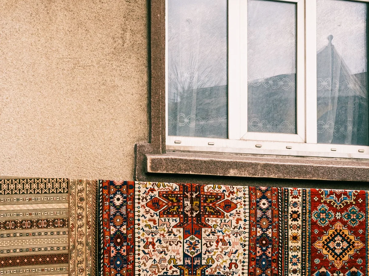 A studio apartment with a rug defining a sofa and sleeping area